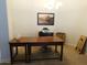Well-lit home office with a wooden desk, artwork, and neutral carpet at 20282 N 104Th Ave, Peoria, AZ 85382