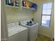 Functional laundry room with a washer, dryer, and ample shelving space at 20282 N 104Th Ave, Peoria, AZ 85382