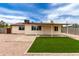 Backyard view with rock landscaping and artifical grass at 2130 W Colter St, Phoenix, AZ 85015