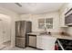 Well-lit kitchen featuring stainless steel appliances and white cabinetry with marble-look countertops at 2130 W Colter St, Phoenix, AZ 85015