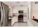 Bright kitchen with stainless steel appliances, white cabinets, and tile flooring at 2130 W Colter St, Phoenix, AZ 85015