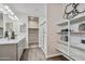 Bright bathroom boasts dual sinks, sleek gray cabinets, and stylish shelving with a glass-enclosed shower at 24047 W Cocopah St, Buckeye, AZ 85326