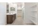 A modern bathroom with double vanity, white countertops and a walk in closet at 24047 W Cocopah St, Buckeye, AZ 85326
