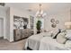 A serene bedroom featuring a decorative light fixture, neutral tones, and stylish artwork at 24047 W Cocopah St, Buckeye, AZ 85326