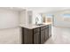 Kitchen island with stainless steel sink and dishwasher surrounded by an open floor plan at 24047 W Cocopah St, Buckeye, AZ 85326