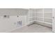 Bright laundry room features tile floors, built-in shelving, and hookups for a washer and dryer at 24047 W Cocopah St, Buckeye, AZ 85326