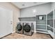 Well-equipped laundry room with modern washer, dryer, shelving, and ample workspace at 24047 W Cocopah St, Buckeye, AZ 85326