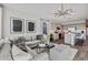 Comfortable living room with large sectional, modern chandelier, and an open view to the kitchen at 24047 W Cocopah St, Buckeye, AZ 85326
