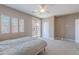 Bright primary bedroom features a ceiling fan, balcony access, and neutral carpeting at 2821 S Skyline Dr # 157, Mesa, AZ 85212