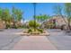 Gated community entrance with lush landscaping, palm trees, and manicured shrubbery at 2821 S Skyline Dr # 157, Mesa, AZ 85212