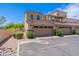Exterior townhome garages and street view showing desert landscaping and lush green bushes at 2821 S Skyline Dr # 157, Mesa, AZ 85212