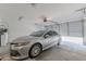 View of a well-lit garage featuring a silver car and an automatic door opener at 2821 S Skyline Dr # 157, Mesa, AZ 85212