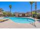 Community pool and lounge area with palm trees, a pool house, and black wrought iron fencing at 2821 S Skyline Dr # 157, Mesa, AZ 85212