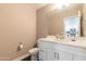 Clean and modern powder room with a white vanity, toilet, and framed mirror at 2821 S Skyline Dr # 157, Mesa, AZ 85212