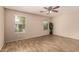 Spacious bedroom with wood-look tile flooring, a ceiling fan, and two windows with natural light at 29161 N Lilly Ln, San Tan Valley, AZ 85143