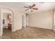 Bedroom featuring wood-look tile flooring, ceiling fan, and view of the bathroom through an arched doorway at 29161 N Lilly Ln, San Tan Valley, AZ 85143