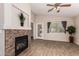 Cozy living room featuring a decorative fireplace, hardwood floors, and a ceiling fan at 29161 N Lilly Ln, San Tan Valley, AZ 85143