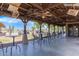 Outdoor patio with rustic wood beams, ceiling fans, tables, and seating overlooks the golf course at 29161 N Lilly Ln, San Tan Valley, AZ 85143