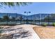 View of well-maintained tennis courts enclosed by high fences and professional lighting at 29161 N Lilly Ln, San Tan Valley, AZ 85143