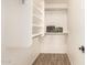 Walk-in closet with built-in shelving and wood-look tile flooring at 29161 N Lilly Ln, San Tan Valley, AZ 85143
