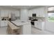 Bright kitchen featuring white cabinets, stainless steel appliances, an island with sink, and neutral countertops at 3013 E Mecklenburg Way, San Tan Valley, AZ 85143