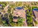 An aerial view of a desert home with a pool, surrounded by greenery and a private drive at 35443 N 87Th Pl, Scottsdale, AZ 85266