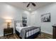 Cozy bedroom featuring a metal-frame bed, wood floors, a nightstand, and modern artwork at 35443 N 87Th Pl, Scottsdale, AZ 85266
