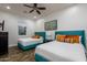 This stylish bedroom has two beds, a modern art piece, and a ceiling fan at 35443 N 87Th Pl, Scottsdale, AZ 85266