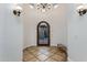 Elegant foyer showcasing a decorative iron door, tiled floor, and sophisticated chandelier at 35443 N 87Th Pl, Scottsdale, AZ 85266