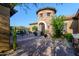 Elegant front entrance featuring stone turret, wrought iron door, and desert landscaping at 35443 N 87Th Pl, Scottsdale, AZ 85266