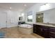 Bright main bathroom features dual vanities, a garden tub, a window, and a glass-enclosed shower at 35443 N 87Th Pl, Scottsdale, AZ 85266