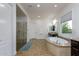Bright main bathroom with separate vanities, a stand-alone shower, and a tub under a window at 35443 N 87Th Pl, Scottsdale, AZ 85266