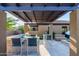 Outdoor kitchen area with a built-in grill, bar seating, and a covered pergola at 35443 N 87Th Pl, Scottsdale, AZ 85266
