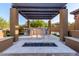 Outdoor kitchen with a pergola, built-in grill, and a fire pit area at 35443 N 87Th Pl, Scottsdale, AZ 85266