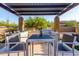 Outdoor kitchen featuring a built-in grill, bar seating, and dining area under a pergola at 35443 N 87Th Pl, Scottsdale, AZ 85266