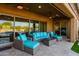 Inviting covered patio with stylish wicker furniture and pool view through sliding glass doors at 35443 N 87Th Pl, Scottsdale, AZ 85266