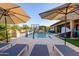 Beautiful backyard pool featuring lounge chairs, umbrellas, and a basketball hoop at 35443 N 87Th Pl, Scottsdale, AZ 85266