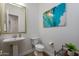 Chic powder room featuring a pedestal sink, modern fixtures, and stylish wall art at 35443 N 87Th Pl, Scottsdale, AZ 85266