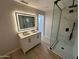 Modern bathroom featuring dual sink vanity, illuminated mirror and frameless shower at 3933 E Flower St, Phoenix, AZ 85018
