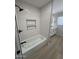 Bathroom featuring modern fixtures, including tiled walls, recessed niche shelving, and a shower/tub combo at 3933 E Flower St, Phoenix, AZ 85018