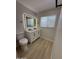 Bathroom featuring a double sink vanity with a lighted mirror and wood-look floors at 3933 E Flower St, Phoenix, AZ 85018
