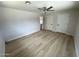 Spacious bedroom with wood-look floors, a ceiling fan, and access to an ensuite bathroom at 3933 E Flower St, Phoenix, AZ 85018