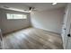 Bedroom featuring wood-look floors, a ceiling fan, and a large window for natural light at 3933 E Flower St, Phoenix, AZ 85018