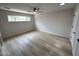 Bright bedroom featuring wood-look flooring, a ceiling fan, and a window for natural light at 3933 E Flower St, Phoenix, AZ 85018