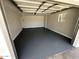 Spacious and clean garage featuring freshly painted walls and flooring with natural lighting at 3933 E Flower St, Phoenix, AZ 85018