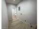 Spacious laundry room with wood-look flooring, including a utility closet and connections at 3933 E Flower St, Phoenix, AZ 85018