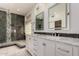 Bathroom featuring double sinks, white cabinets and a step-in shower at 408 E Silverwood Dr, Phoenix, AZ 85048