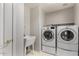 A well-lit laundry room with a sink, a washer, and a dryer at 408 E Silverwood Dr, Phoenix, AZ 85048
