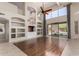 Spacious living room with wood floors, built-in shelves, high ceilings, and backyard view at 408 E Silverwood Dr, Phoenix, AZ 85048