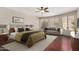 This main bedroom features a sitting area, a ceiling fan, and hardwood floors at 408 E Silverwood Dr, Phoenix, AZ 85048